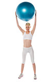 Sporty woman holding ball over her head