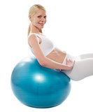 Beautiful teenage girl back stretch over exercise ball
