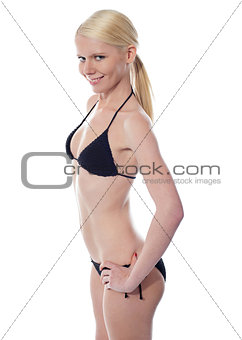 The slim suntanned girl in bikini