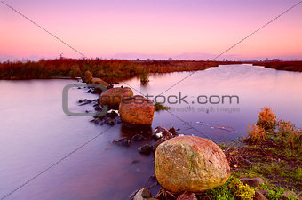 big stones on river at sunrise