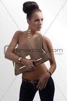 fashion brunette in jeans with big bag looks at left