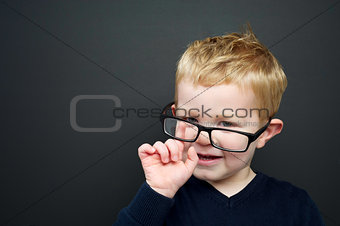 Smart young boy stood infront of a blackboard