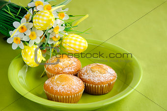 Easter cakes on plate with flowers on green