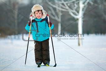 Cute five years old boy skiing on cross