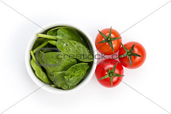 fresh spinach leaves in bowl and tomatoes