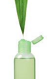 Green cosmetic bottle and leaf