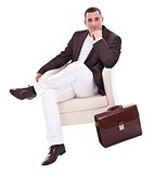 Handsome businessman sitting in armchair