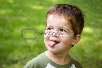 Cute little boy sticking out his tongue