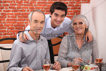Elderly couple and grandson in restaurant