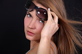 Portrait of a woman raising her sunglasses