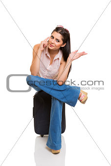 Young woman sitting on suitcase