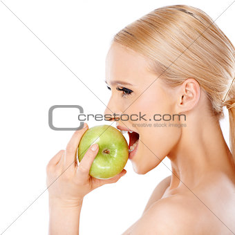 Side view of blond woman  she bites an apple