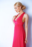 Sensual blond woman posing in pink dress