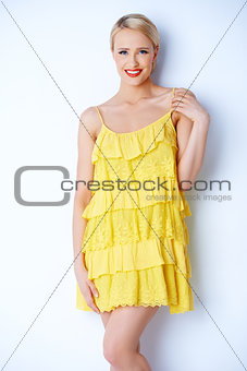 Attractive blond young woman posing in yellow dress