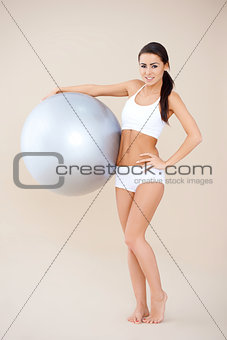 Fitness woman standing with gym ball