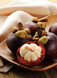 fresh exotic fruit mangosteen on a wooden plate