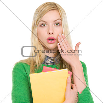 Portrait of surprised student girl with books