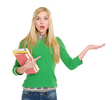 Surprised student girl pointing on empty hand