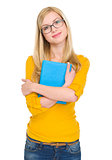 Portrait of happy student girl in glasses hugging book