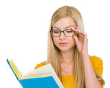 Student girl in glasses reading book