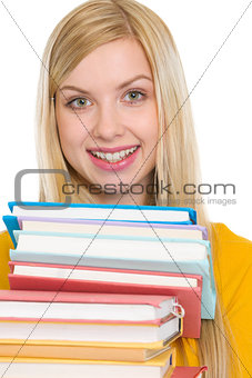 Happy student girl holding stack of books
