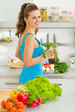 Young housewife preparing vegetables in kitchen