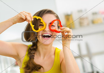 Funny young woman showing slices of bell pepper