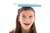 Symbolic picture: Girl holding a book on her head