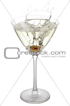 Olive splashing into a cocktail glass