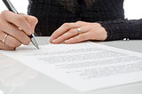 Business woman signing a contract above signature line