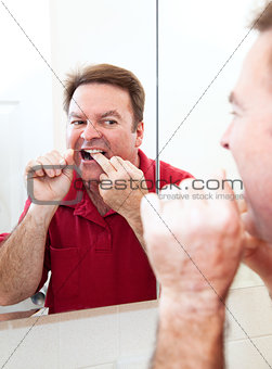 Flossing Teeth In Bathroom Mirror