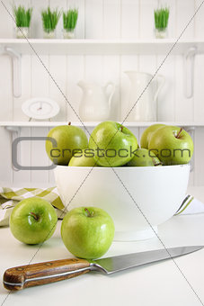 Green apples in bowl on table