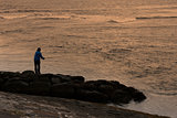 A man fishing at sunset