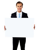 Young businessman holding white blank billboard