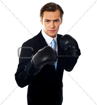 Handsome businessman posing in boxing gloves