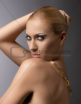 blonde girl with necklace lookd in to the lens