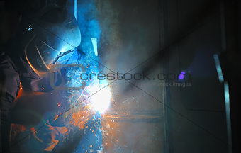 Industrial worker welding in factory