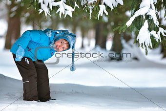 Cute five years old boy playing on winter forest