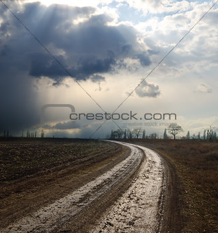 dramatic sky over field with dirty road