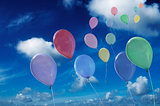 colored ballons against cloudy sky