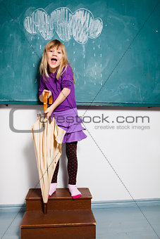 Young girl with umbrella indoors