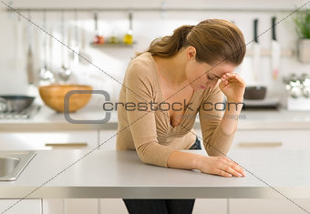 Stressed young woman in kitchen