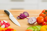 Closeup on onion slices and knifes on cutting board