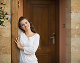 Portrait of happy young woman at doorstep