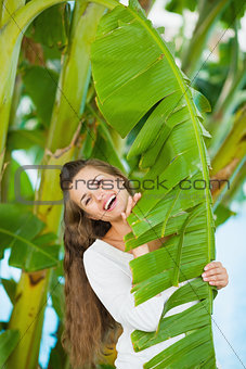 Portrait of smiling young woman among tropical palms