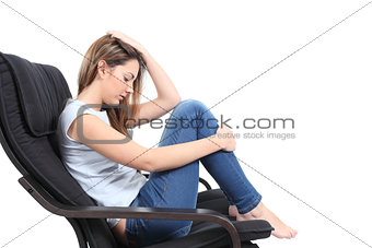 Beautiful teenager worried sitting on an armchair