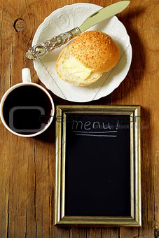 Coffee cup and bun with butter with  slate chalk board