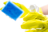Gloved hand holding a detergent spray and a sponge