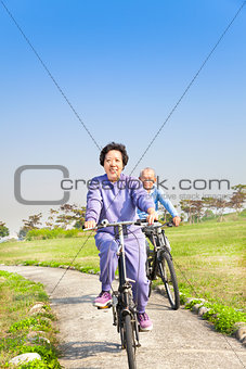 asian seniors couple biking in the park