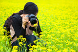 young woman photographer taking pictures in nature